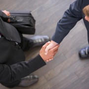 Two businessmen indoors shaking hands
